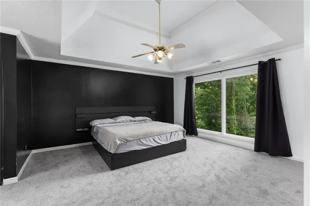 a spacious bedroom with a bed and a large window