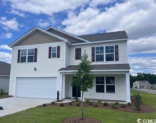 4079 Nelson Road Little River, SC 29566 - Photo 1 of 37 View of front of home with concrete driveway, a front lawn, a garage, and covered porch