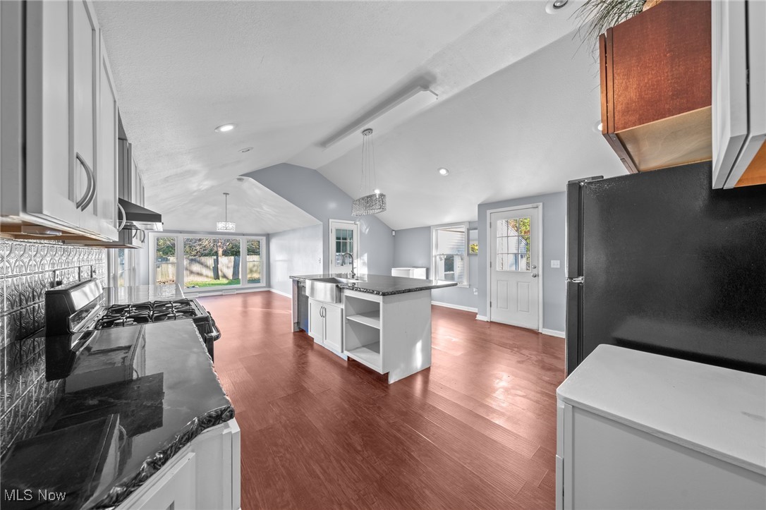 5865 Ruple Parkway Brook Park, OH 44142 - Photo 15 of 45 Kitchen with white cabinetry, decorative light fixtures, black refrigerator, and vaulted ceiling