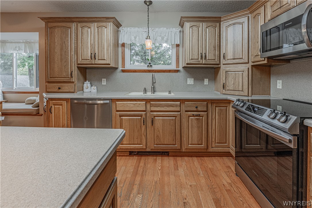 6775 Bear Ridge Road Pendleton, NY 14094 - Photo 11 of 48 Rich wood cabinetry and warm hardwood flooring anchor this well-appointed kitchen.