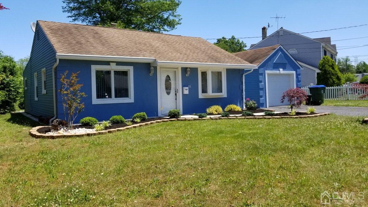 a front view of house with yard outdoor seating and garage