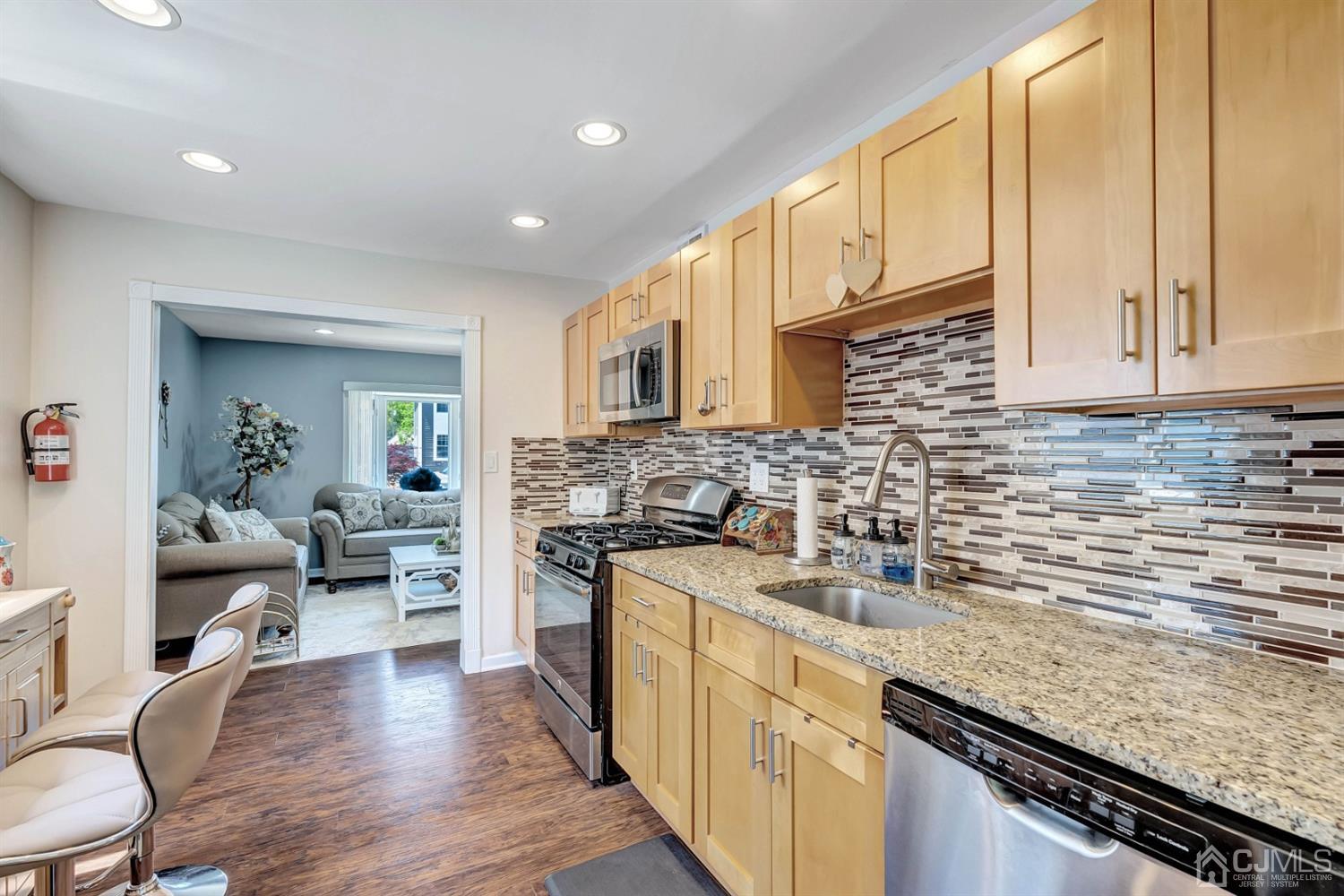 30 West Knollwood Road Edison, NJ 08817 - Photo 8 of 17 a kitchen with stainless steel appliances granite countertop a sink stove and cabinets