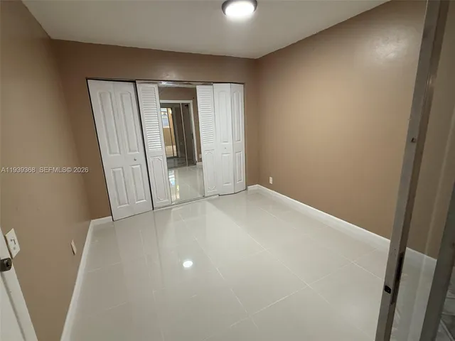 an empty room with closet and mirror