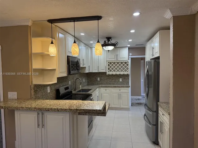 a large kitchen with a refrigerator a sink and a stove
