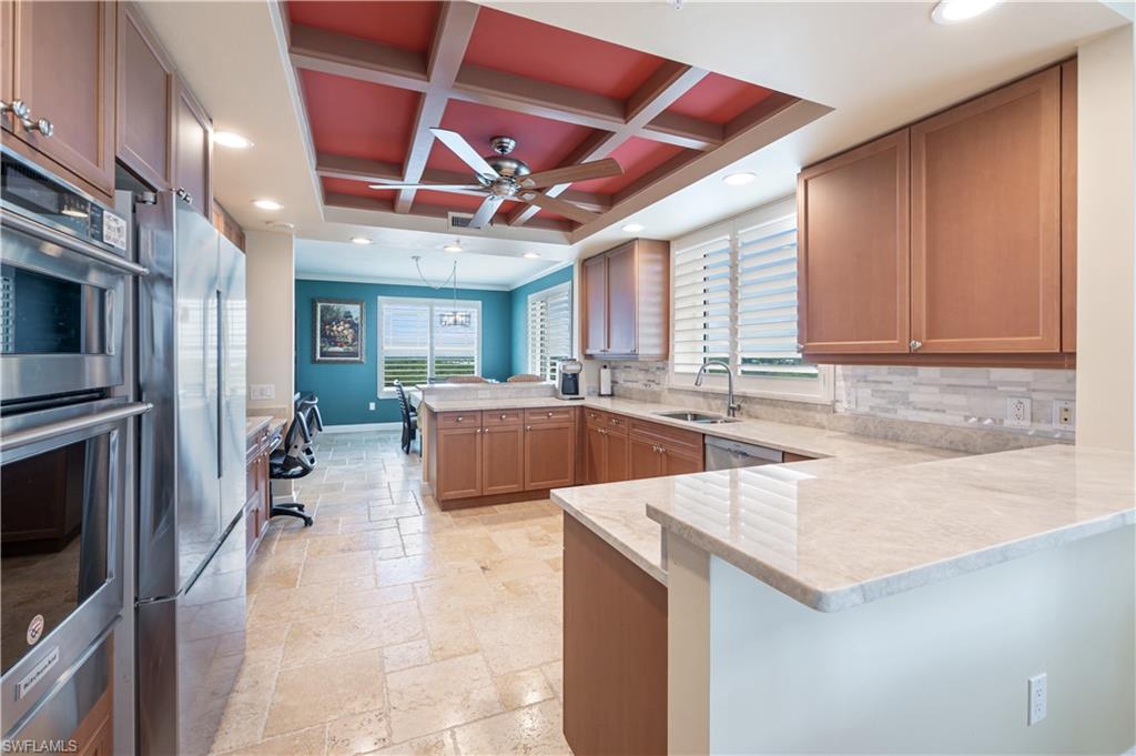 455 Cove Tower Drive, Unit 1101 Naples, FL 34110 - Photo 13 of 49 a kitchen with a sink a counter top space cabinets stainless steel appliances and a window