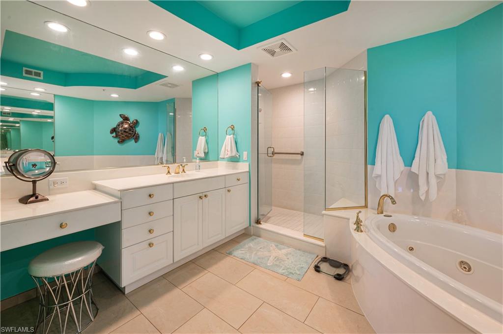 455 Cove Tower Drive, Unit 1101 Naples, FL 34110 - Photo 22 of 49 a spacious bathroom with a double vanity sink a mirror and a bathtub
