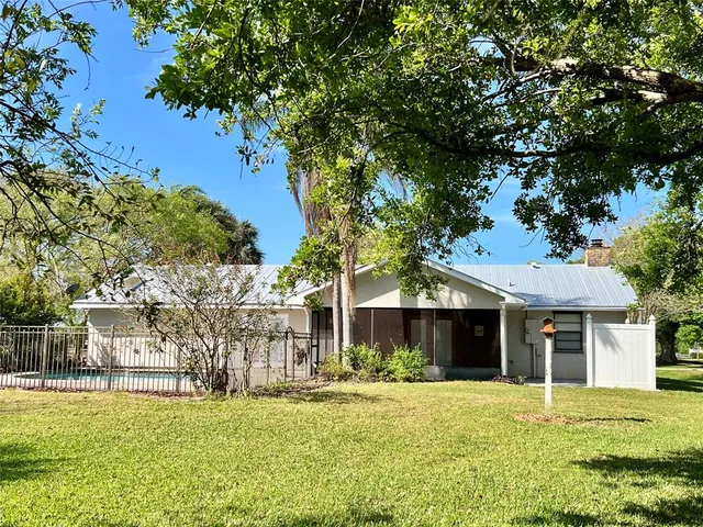 a front view of a house with a garden and trees