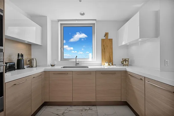 a kitchen with granite countertop white cabinets and stainless steel appliances