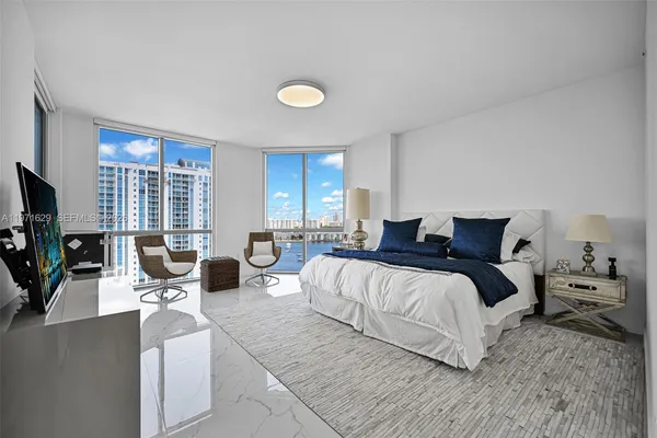 a bedroom with a bed and a flat tv screen on dresser