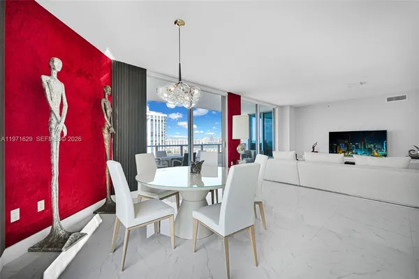 a living room with furniture a floor to ceiling window and potted plants
