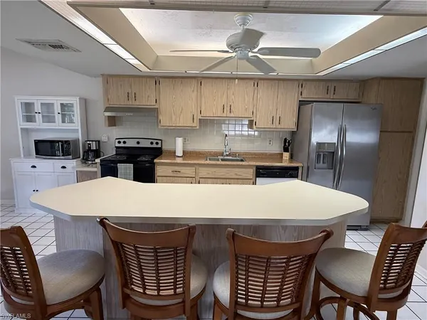 a kitchen with stainless steel appliances a table chairs and refrigerator