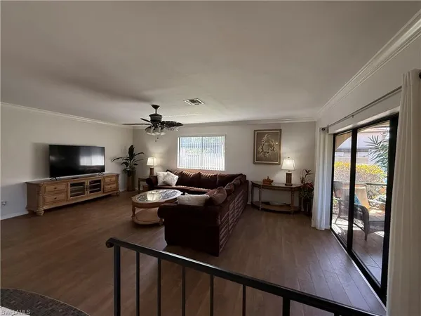 a living room with furniture a flat screen tv and a large window