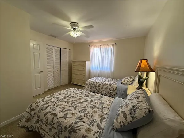 a bedroom with two beds and a chandelier