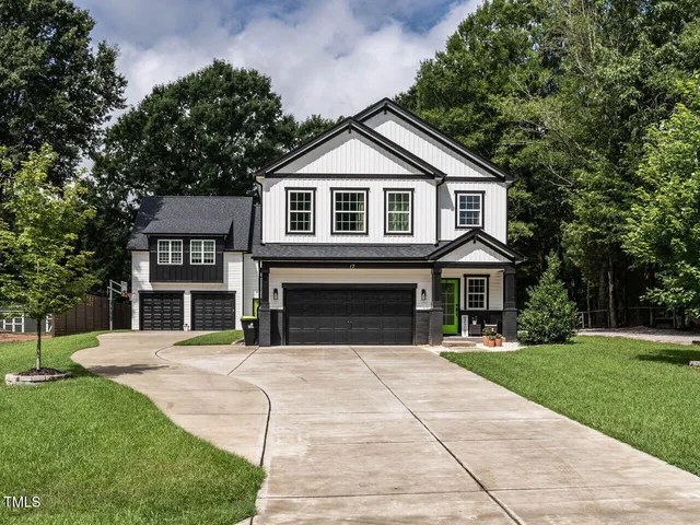 a front view of a house with yard and green space