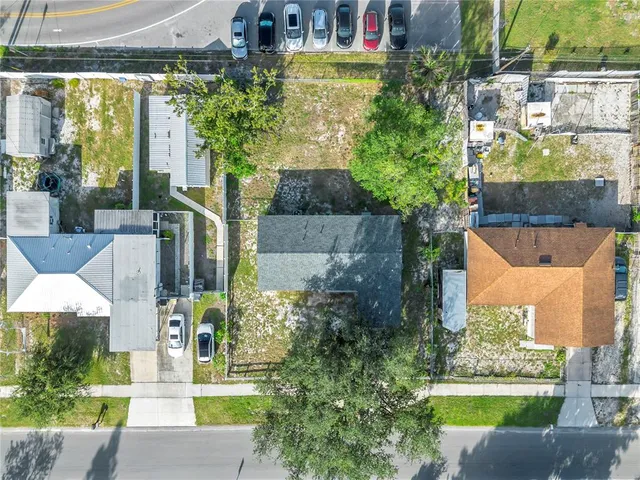 a front view of a house with a yard and potted plants