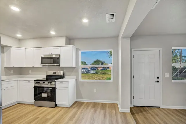 a kitchen with stainless steel appliances granite countertop a refrigerator and a stove top oven