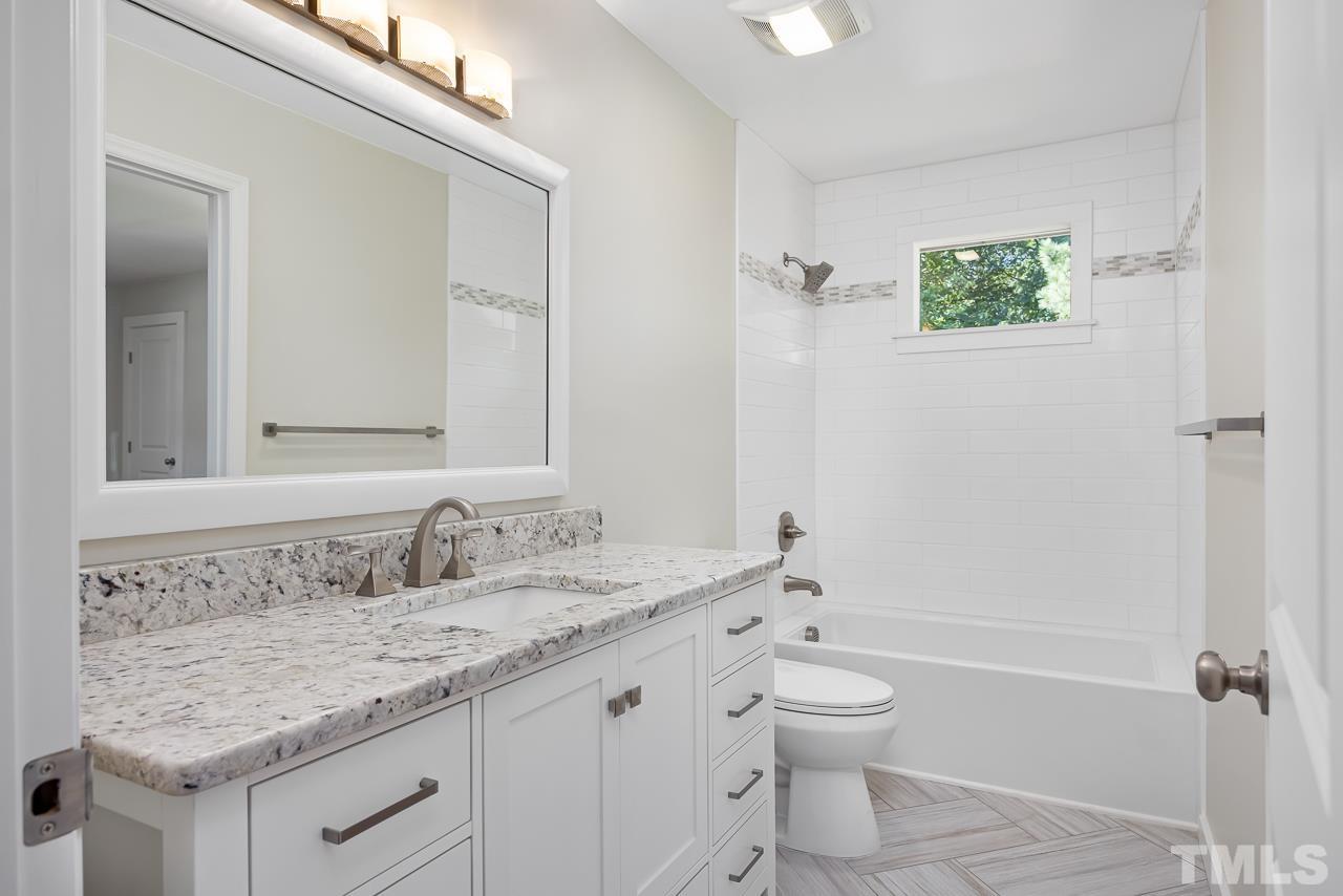 500 Doby Circle Raleigh, NC 27610 - Photo 24 of 40 a bathroom with a granite countertop toilet a sink and a bathtub