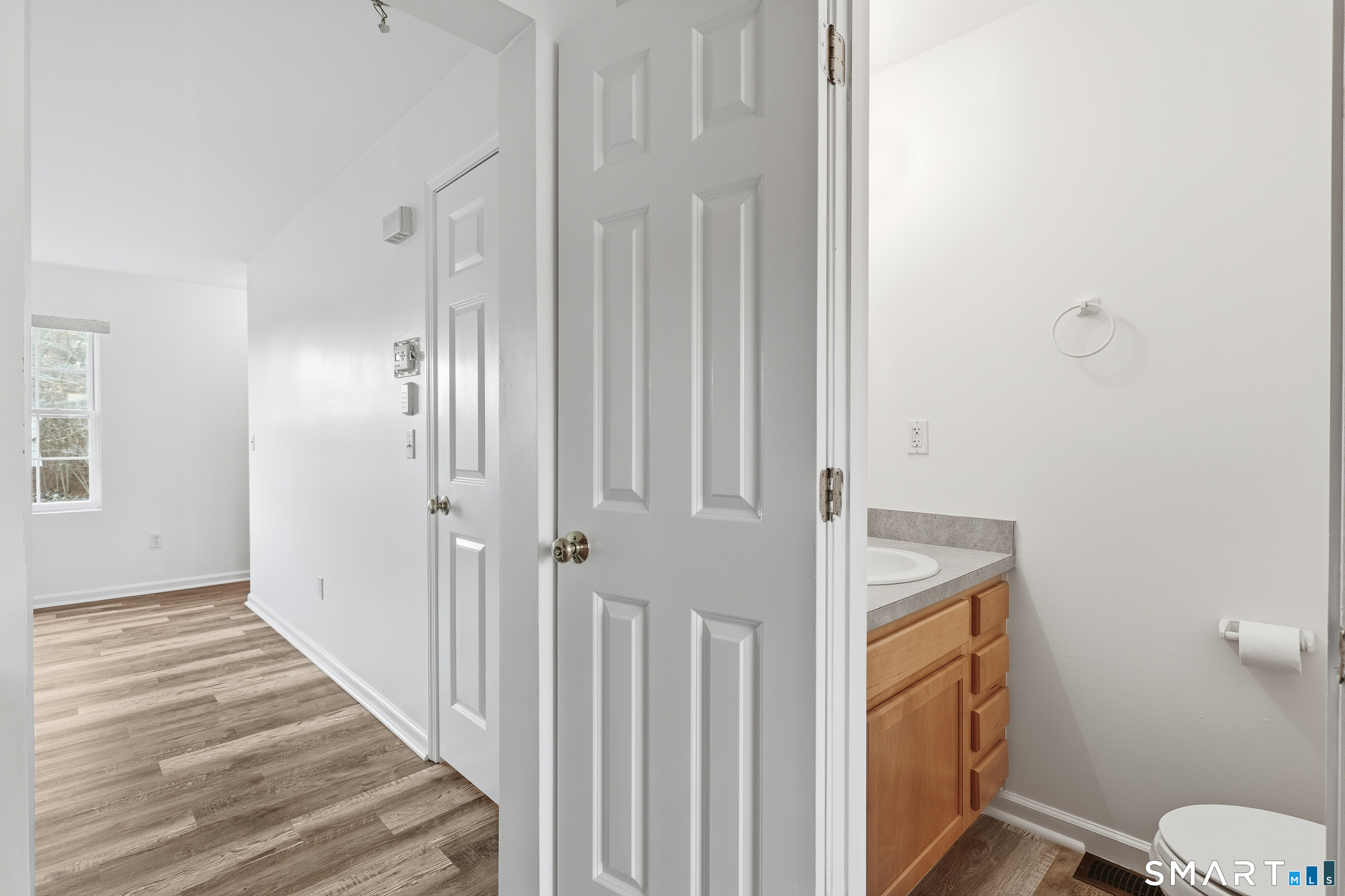 135 Bucks Hill Road, Unit 10 Waterbury, CT 06704 - Photo 6 of 20 a view of a hallway with wooden floor and bathroom