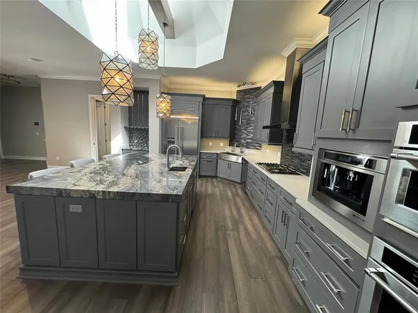 a kitchen with stainless steel appliances granite countertop a sink stove and refrigerator