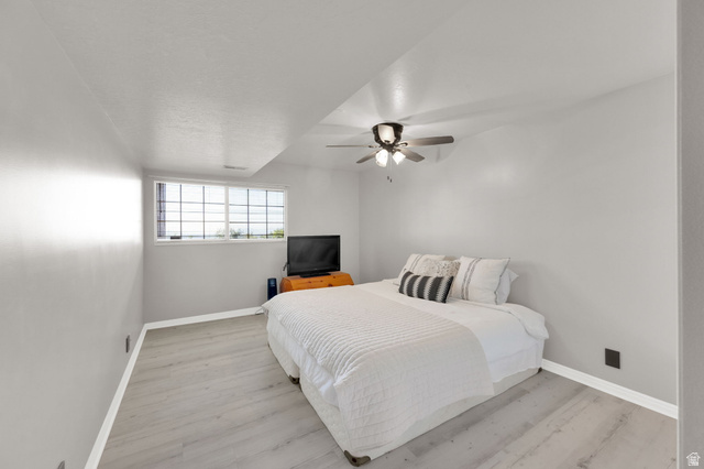 5057 South Ridgedale Drive Ogden, UT 84403 - Photo 48 of 69 Room featuring light gray walls, wood-finish flooring, a multi-pane window, and a ceiling fan with integrated lighting