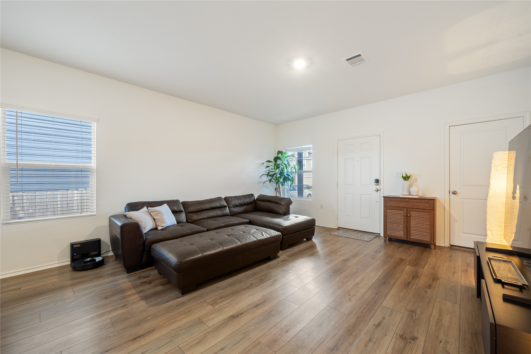 14404 Berning Road Manor, TX 78653 - Photo 6 of 38 A well-lit living area features warm wood-look flooring and a functional layout.