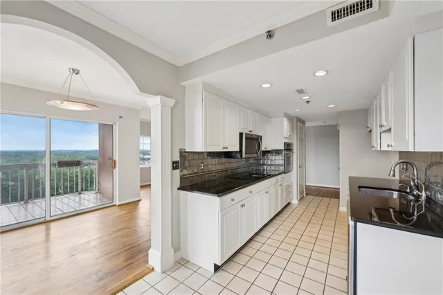 a kitchen with granite countertop a sink stainless steel appliances and cabinets