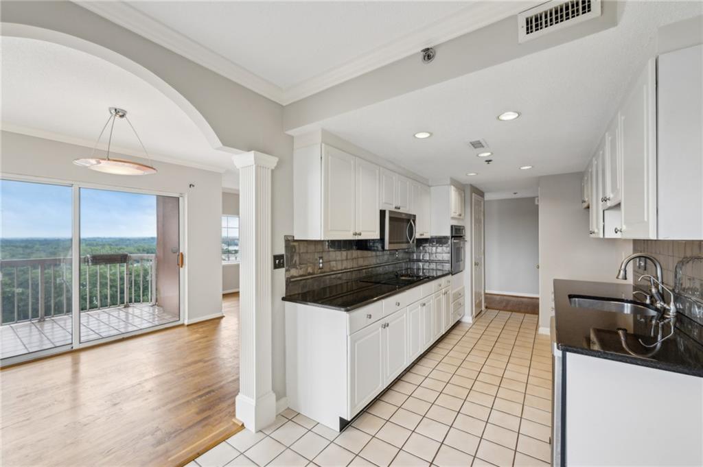 3435 Kingsboro Road Northeast, Unit 1702 Atlanta, GA 30326 - Photo 17 of 35 a large kitchen with stainless steel appliances granite countertop a large counter top a stove and a sink