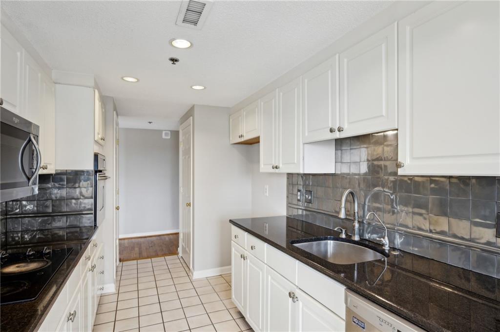3435 Kingsboro Road Northeast, Unit 1702 Atlanta, GA 30326 - Photo 18 of 35 a kitchen with granite countertop a sink stainless steel appliances and cabinets