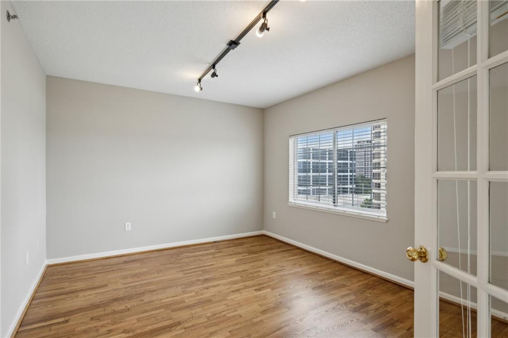 3435 Kingsboro Road Northeast, Unit 1702 Atlanta, GA 30326 - Photo 21 of 35 an empty room with wooden floor and windows
