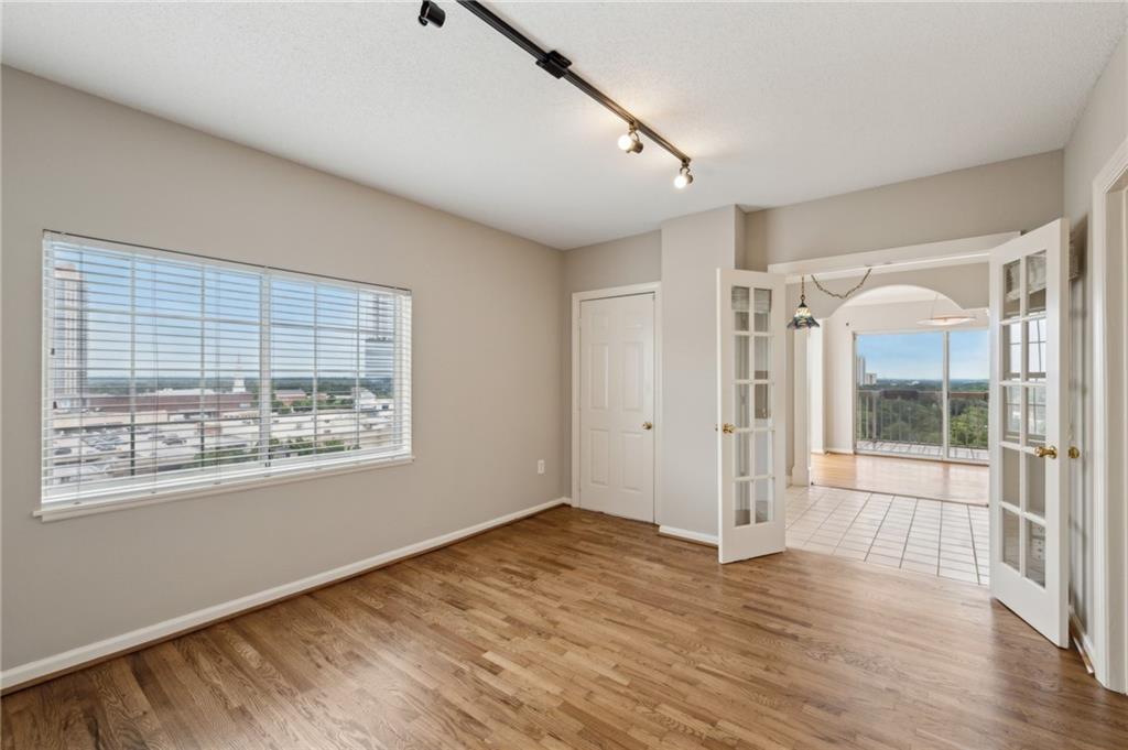 3435 Kingsboro Road Northeast, Unit 1702 Atlanta, GA 30326 - Photo 23 of 35 a view of an empty room with wooden floor and a window