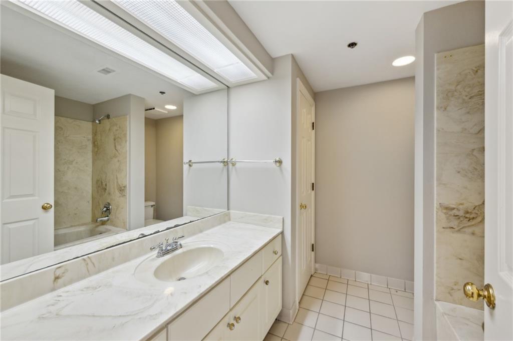 3435 Kingsboro Road Northeast, Unit 1702 Atlanta, GA 30326 - Photo 24 of 35 a bathroom with a sink and a mirror