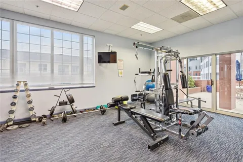 a room with gym equipment and large mirror