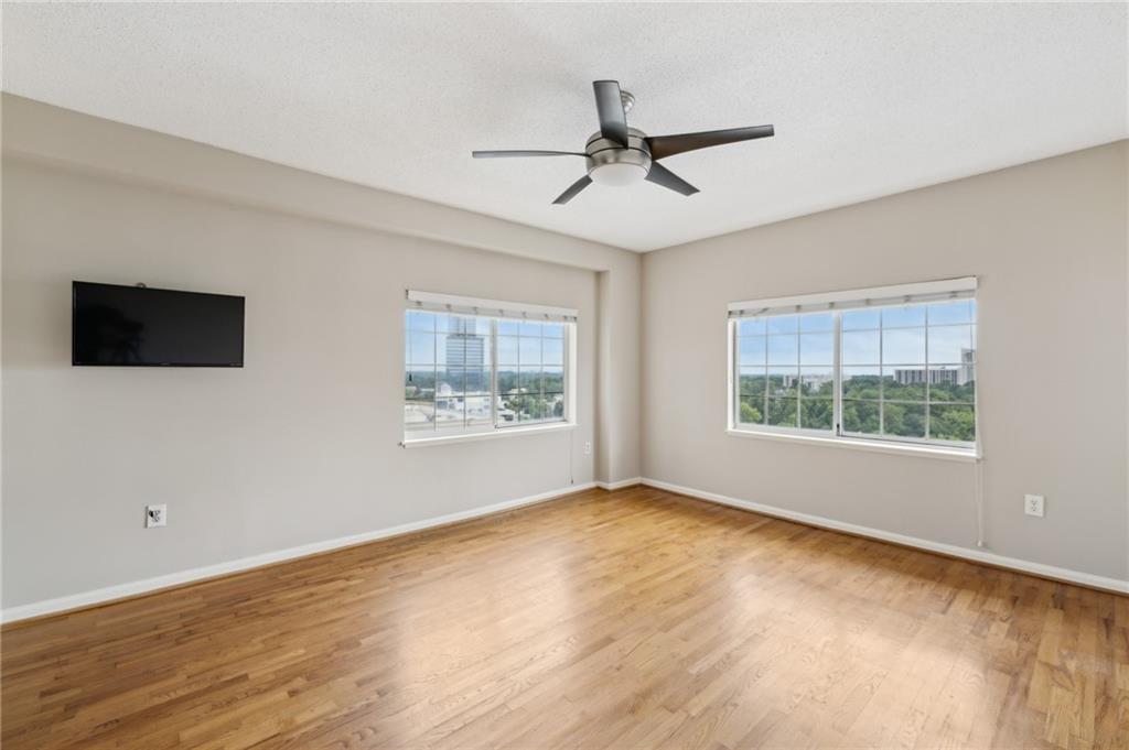 3435 Kingsboro Road Northeast, Unit 1702 Atlanta, GA 30326 - Photo 9 of 35 a view of an empty room with wooden floor and a window
