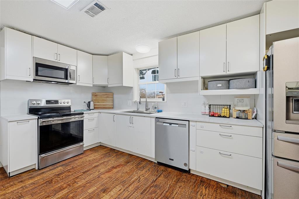 85 Quail Run Road Sherman, TX 75090 - Photo 11 of 31 a kitchen with stainless steel appliances white cabinets and a sink