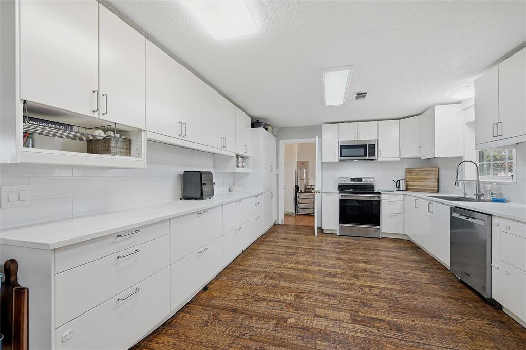 85 Quail Run Road Sherman, TX 75090 - Photo 13 of 31 a large white kitchen with cabinets and stainless steel appliances