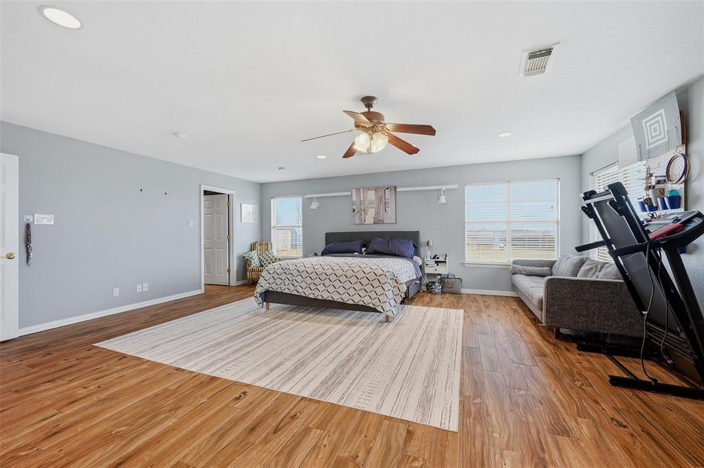 85 Quail Run Road Sherman, TX 75090 - Photo 17 of 31 a bedroom with a bed and wooden floor