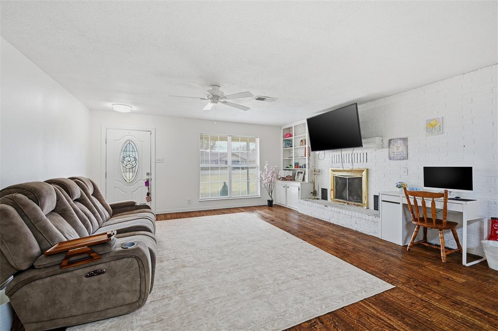 85 Quail Run Road Sherman, TX 75090 - Photo 5 of 31 a living room with furniture a fireplace and a flat screen tv