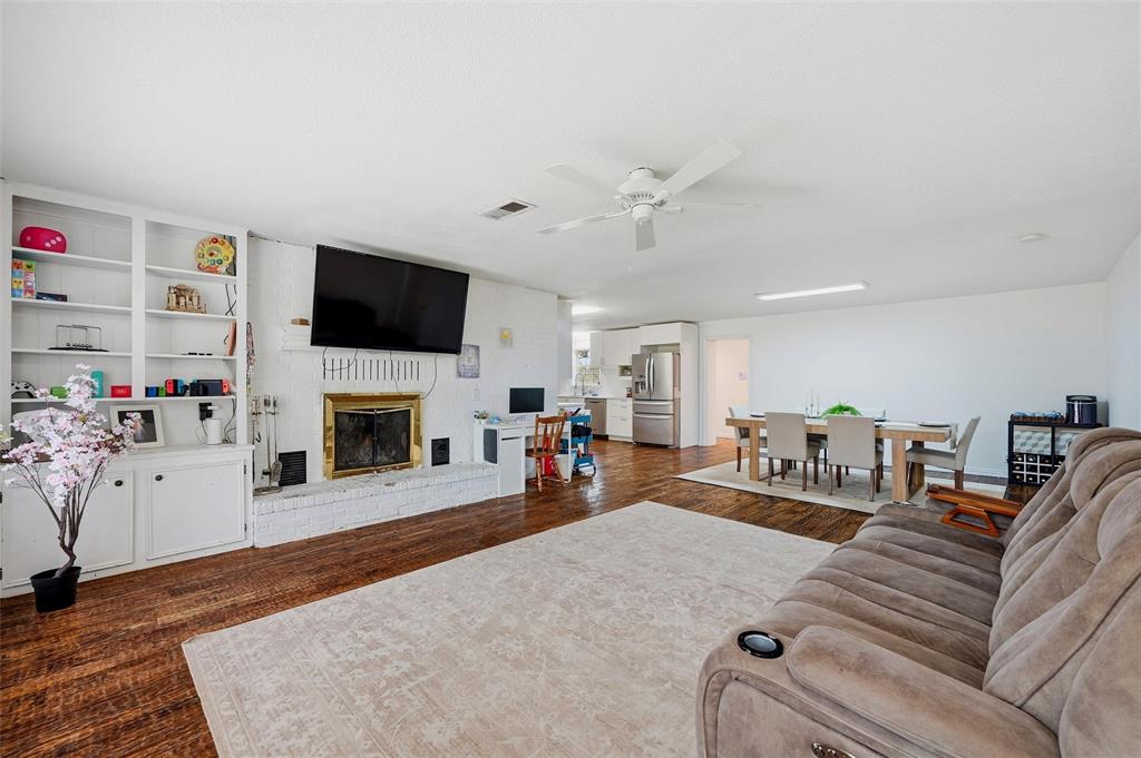 85 Quail Run Road Sherman, TX 75090 - Photo 6 of 31 a living room with furniture a fireplace and a flat screen tv
