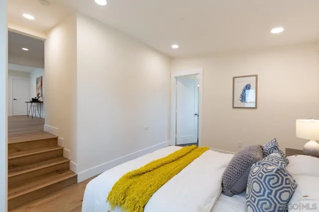 a bedroom with a bed and wooden floor
