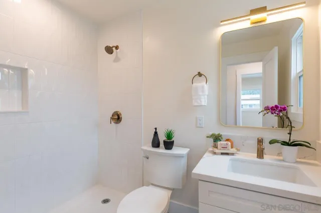 a bathroom with a sink a toilet and a mirror