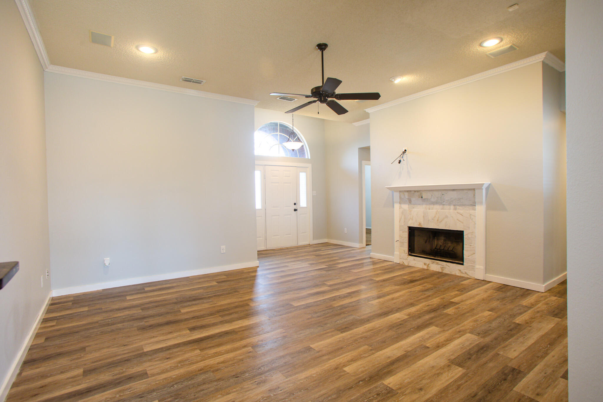 6916 Fulton Avenue Lubbock, TX 79424 - Photo 3 of 24 a view of empty room with wooden floor and fireplace