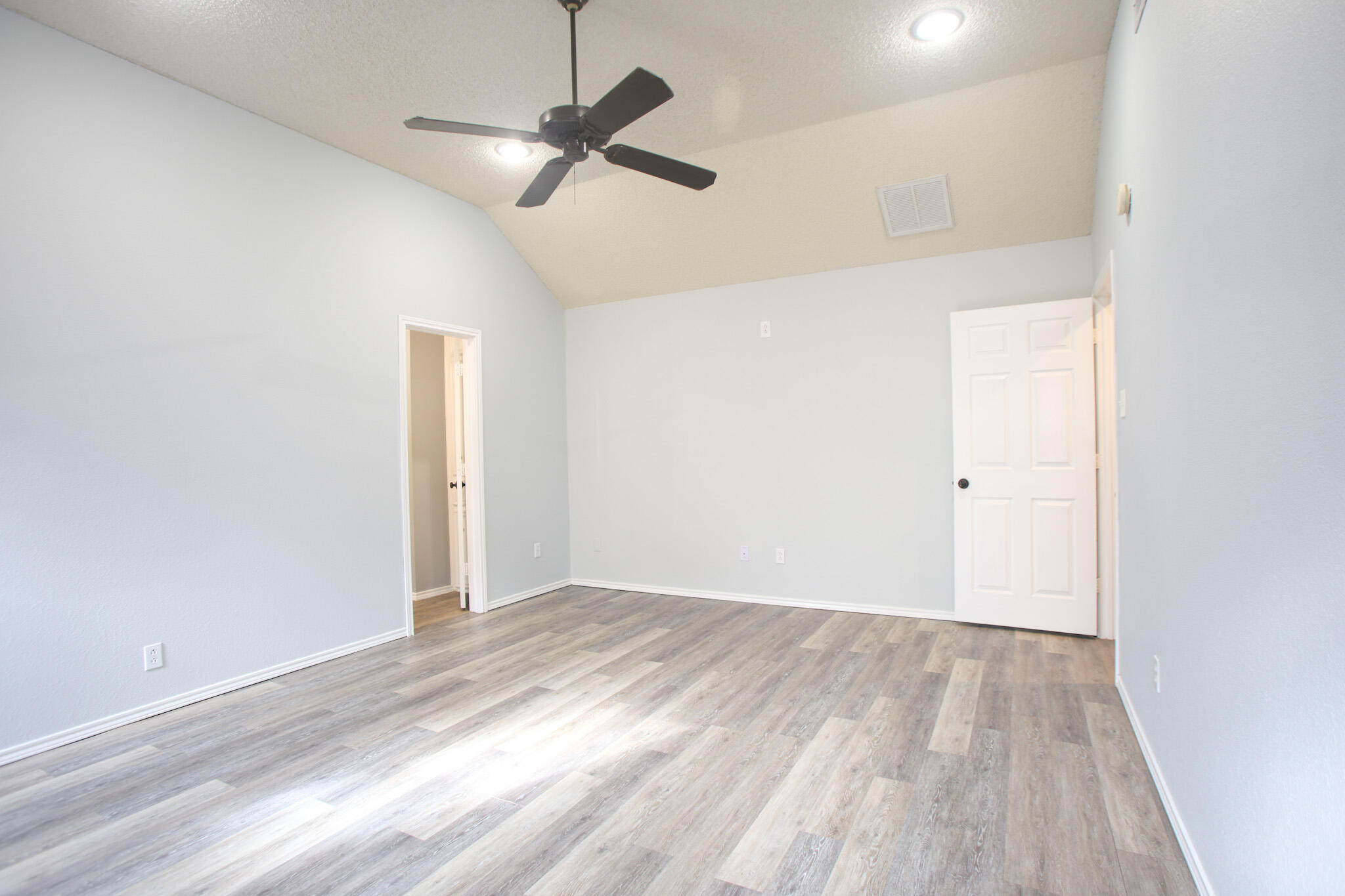 6916 Fulton Avenue Lubbock, TX 79424 - Photo 10 of 24 an empty room with wooden floor ceiling fan and windows