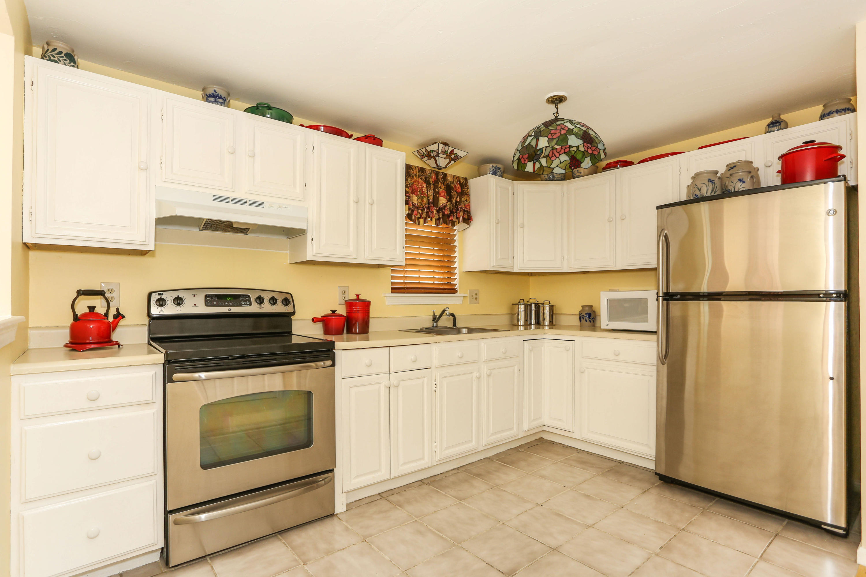 385 Skunknet Road Centerville, MA 02632 - Photo 16 of 32 a kitchen with a refrigerator sink and cabinets