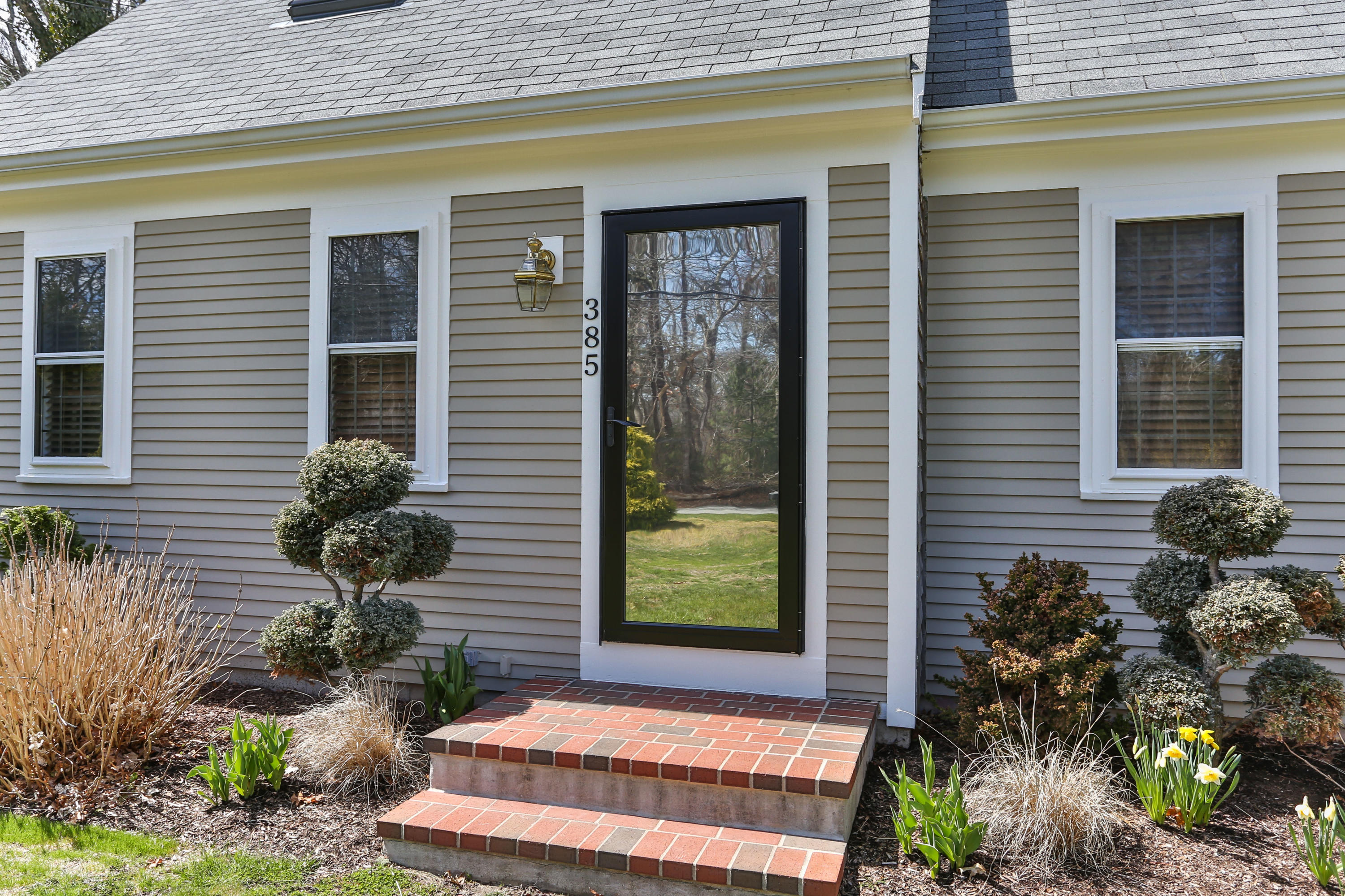 385 Skunknet Road Centerville, MA 02632 - Photo 3 of 32 a front view of a house with a yard