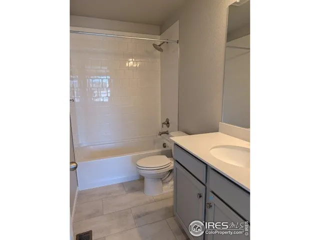 a bathroom with a granite countertop toilet a sink and a mirror