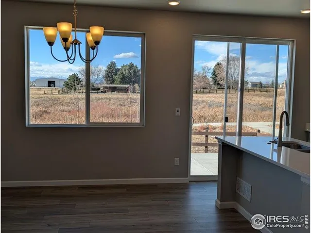 a view of a room with wooden floor and large windows