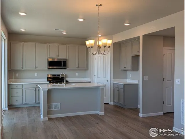 a kitchen with kitchen island granite countertop a sink cabinets and stainless steel appliances