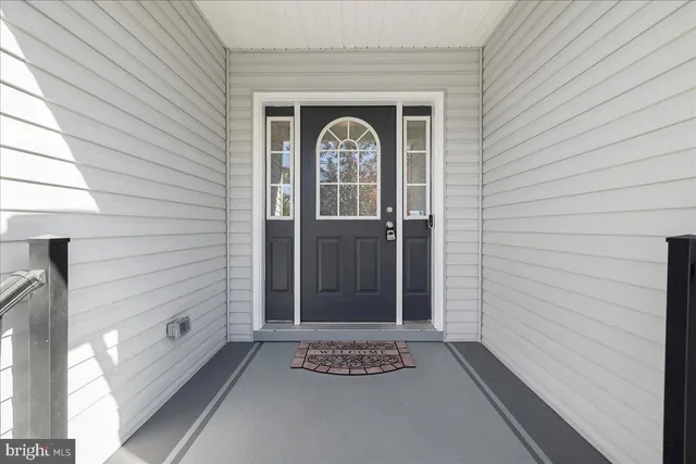 a kitchen with stainless steel appliances granite countertop a refrigerator a sink dishwasher a stove and white countertops with wooden floor