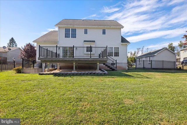 a view of a house with a backyard and a tree