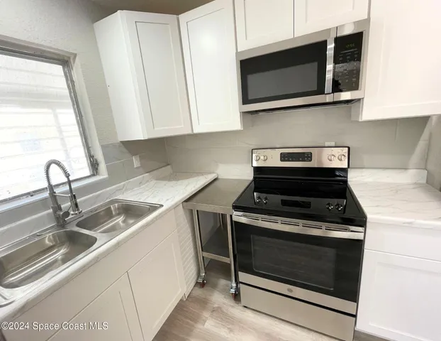 a kitchen with stainless steel appliances granite countertop a stove microwave and sink